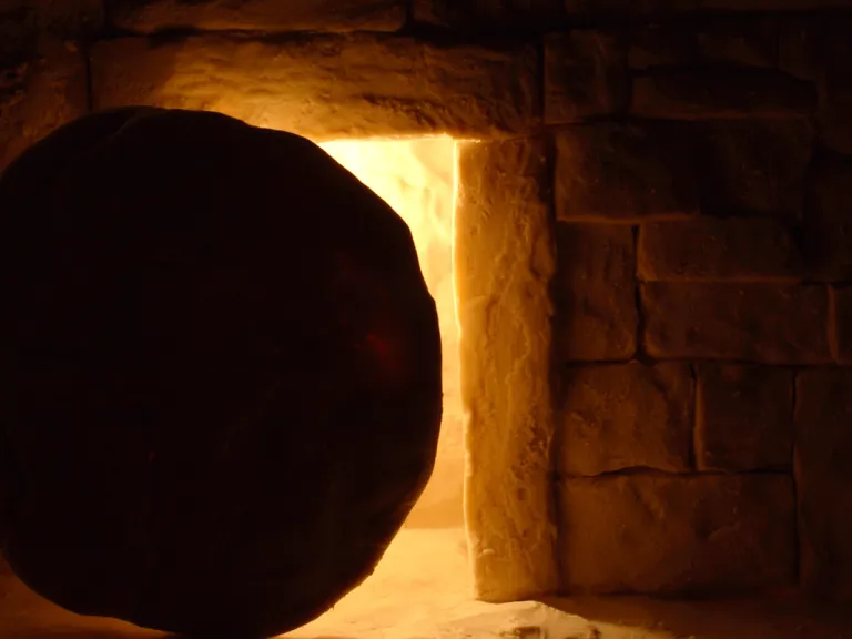 A round stone in front of a tomb.