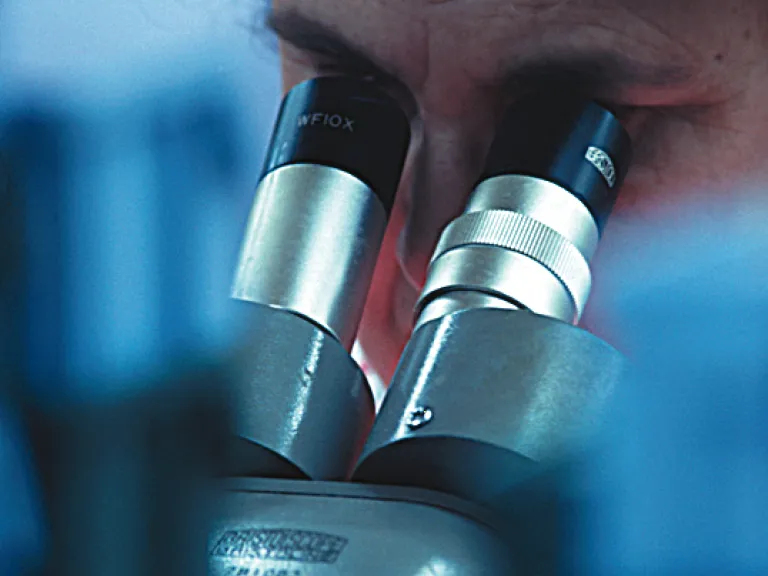A scientist using a microscope.