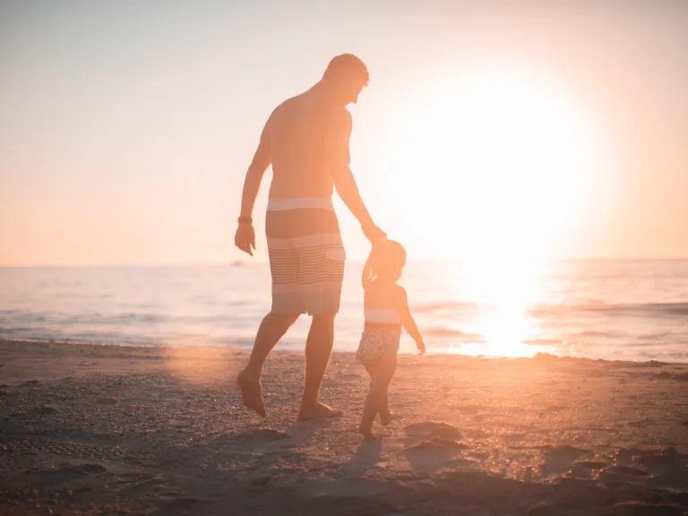 A father and child walking on the beach