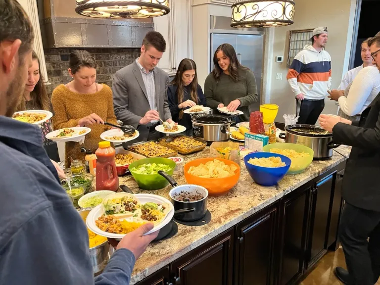 A group of young adults assembling tacos