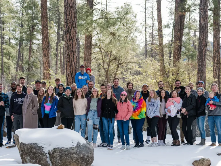 A group of young adults standing in the snow