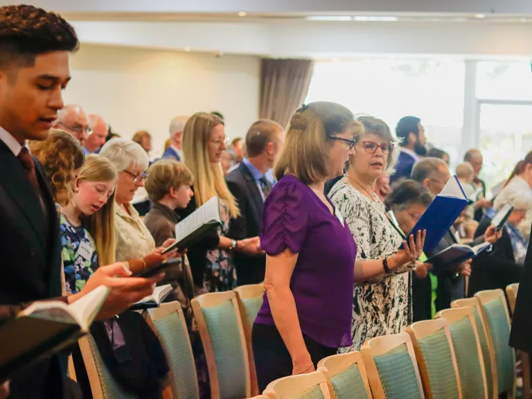 a group of people singing hymns in church