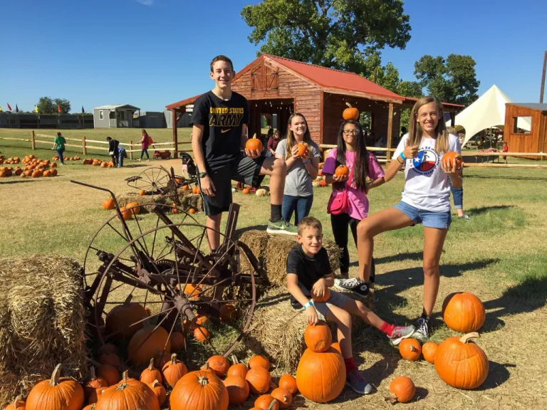 a group of young people with pumpkins