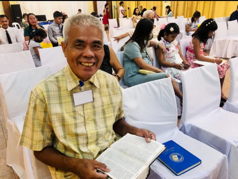 a man sitting with an open Bible