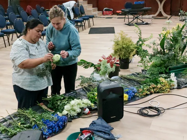 two ladies assembling floral arrangements