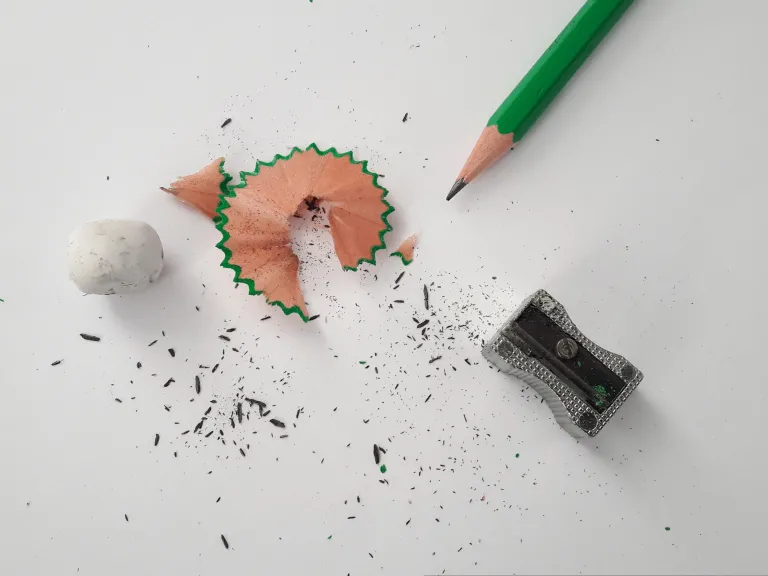 a pencil, a sharpener and a pencil shaving
