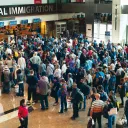 Airport travelers standing in line to go through immigration customs.