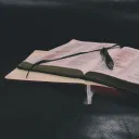 A Bible and notebook laying on a table.