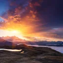 Raios solares sobre uma montanha e um lago.