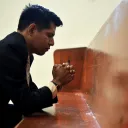 a man with hands folded in prayer