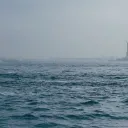 The Statue of Liberty in the distance from the ocean.